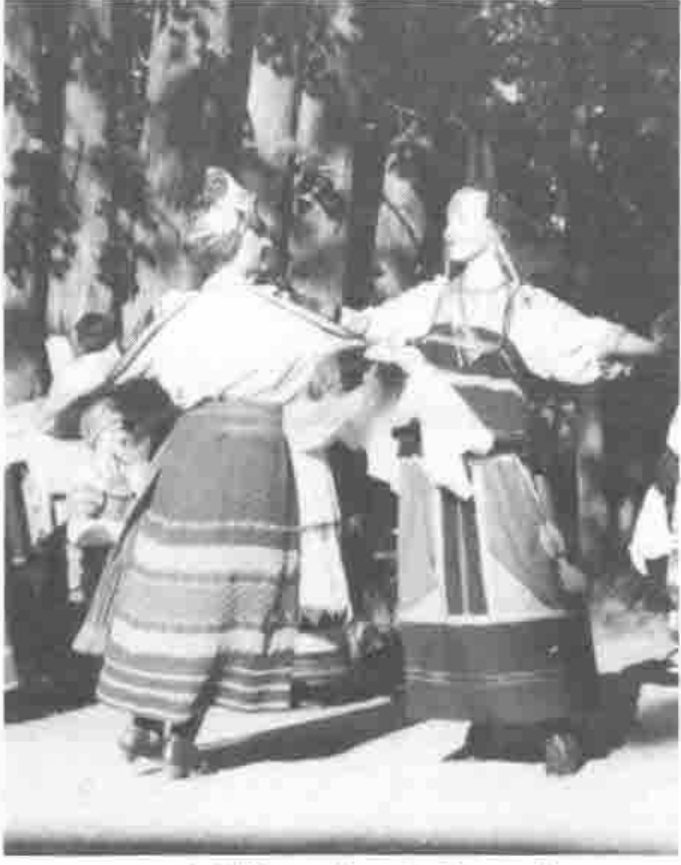 Two dancers in folk costume whirling, arms linked