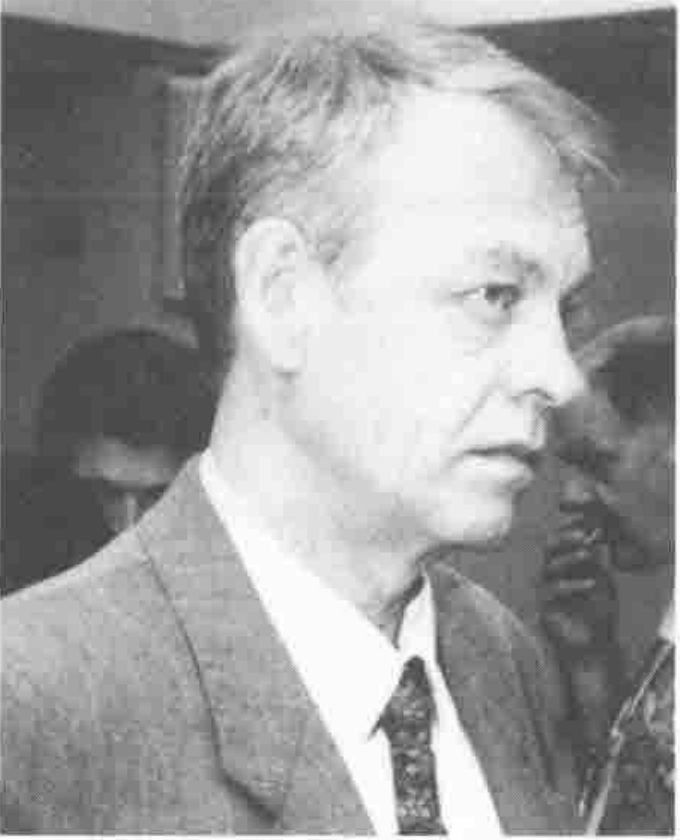 Head and shoulders of a grey-haired man in a suit