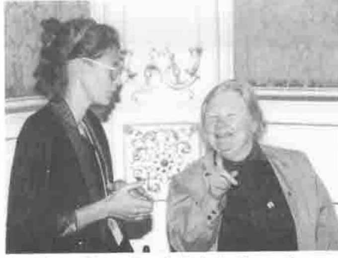 Two women laughing in an ornate room