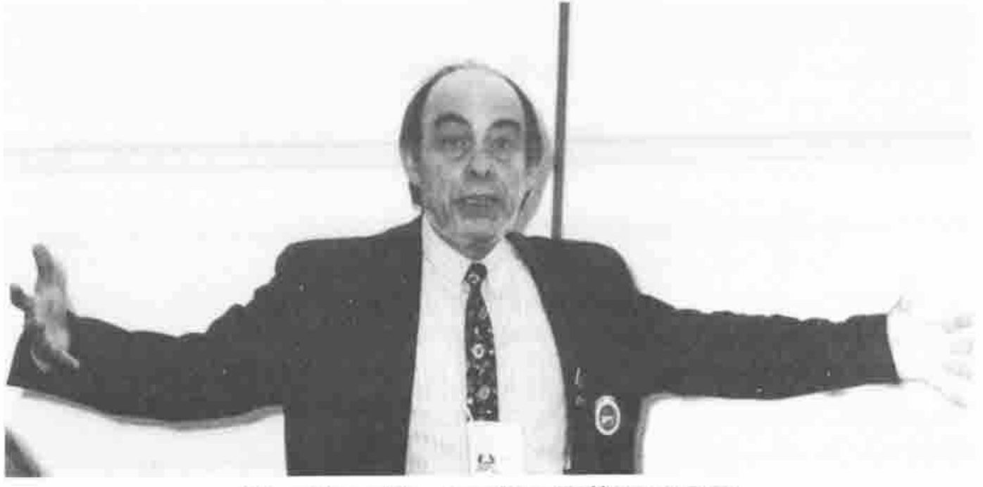 A man lecturing with his arms stretched wide