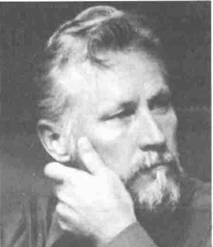 A bearded man with his chin on his hand