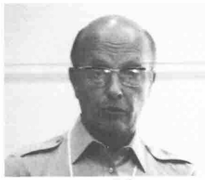 Head and shoulders of a bald man in glasses