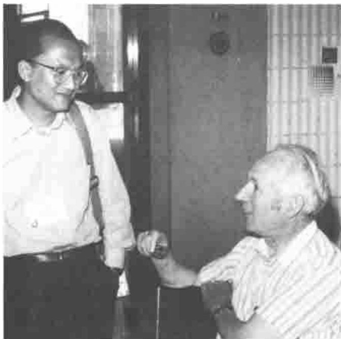 Roger Hui, smiling, beside a seated Donald McIntyre