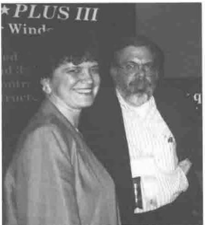 A woman and a bearded man in front of an APL*PLUS III sign