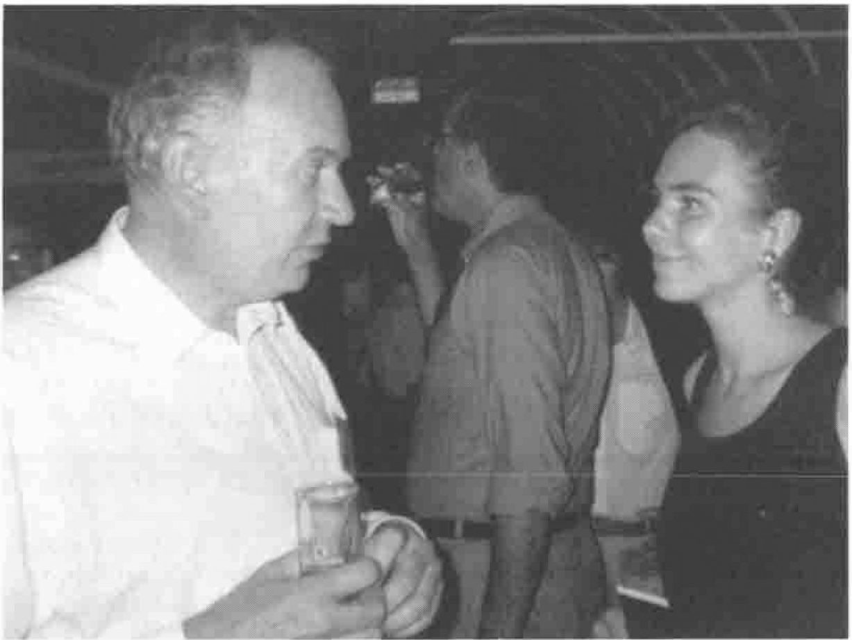John Scholes talking to a smiling woman at an evening gathering