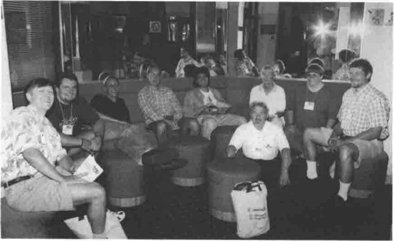 A group seated on round stools and a sofa in a hotel lobby