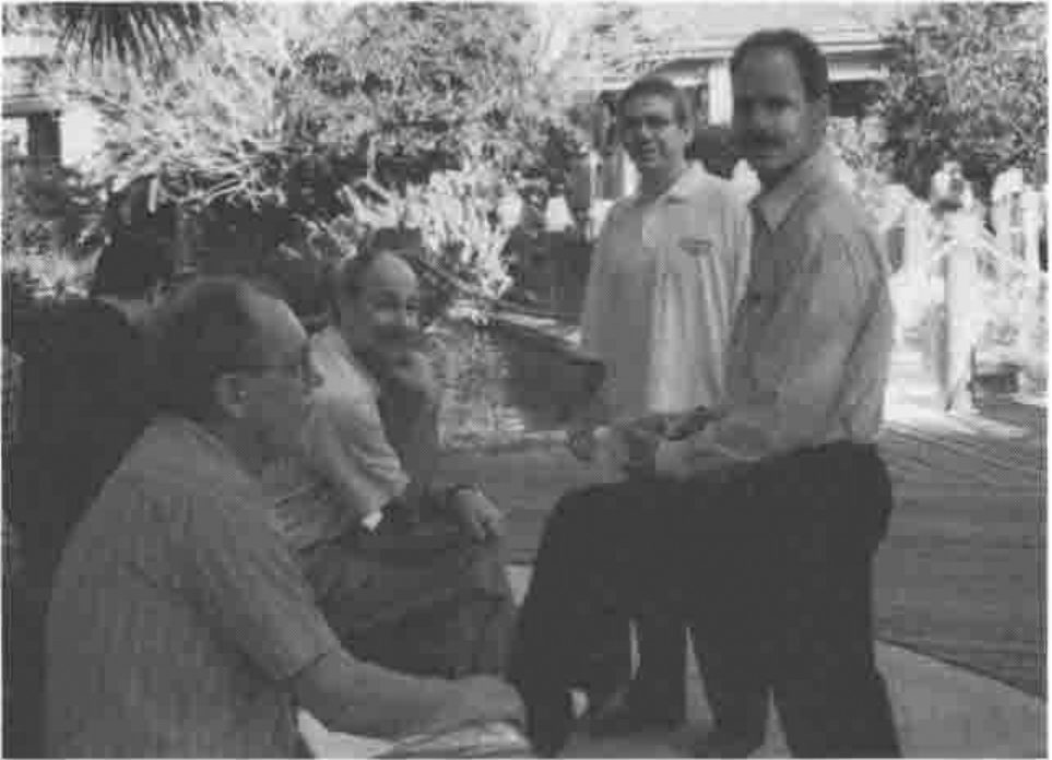 Five delegates talking in the hotel garden, two of them seated