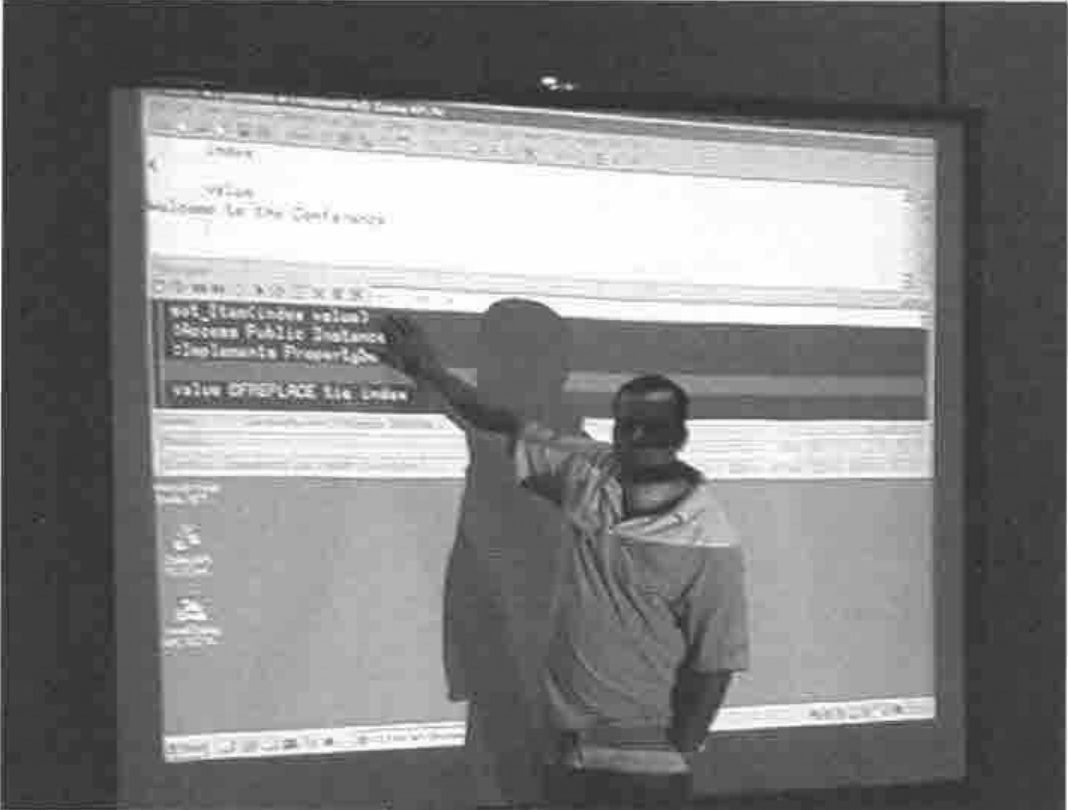 John Daintree pointing at a projected Dyalog session