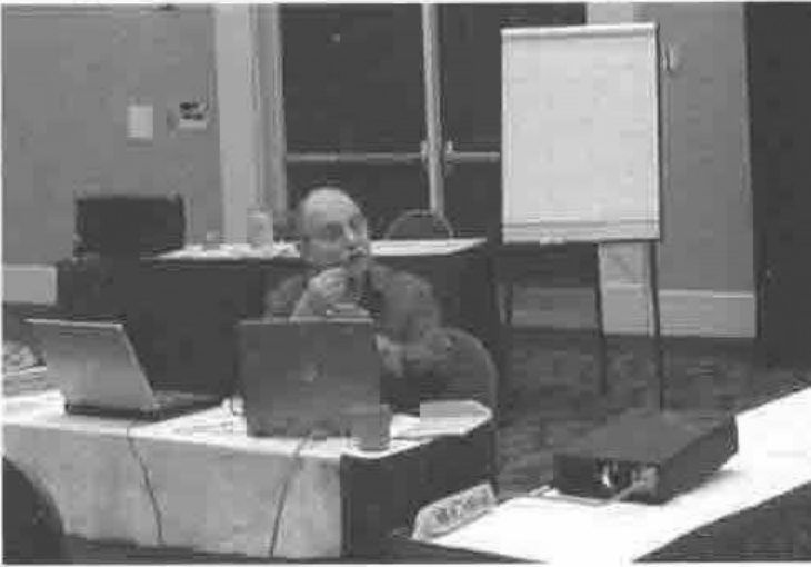 Larry Mysz presenting, seated behind laptops