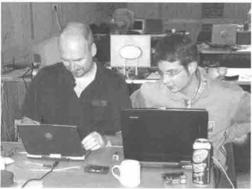 Two programmers at laptops in the village hall
