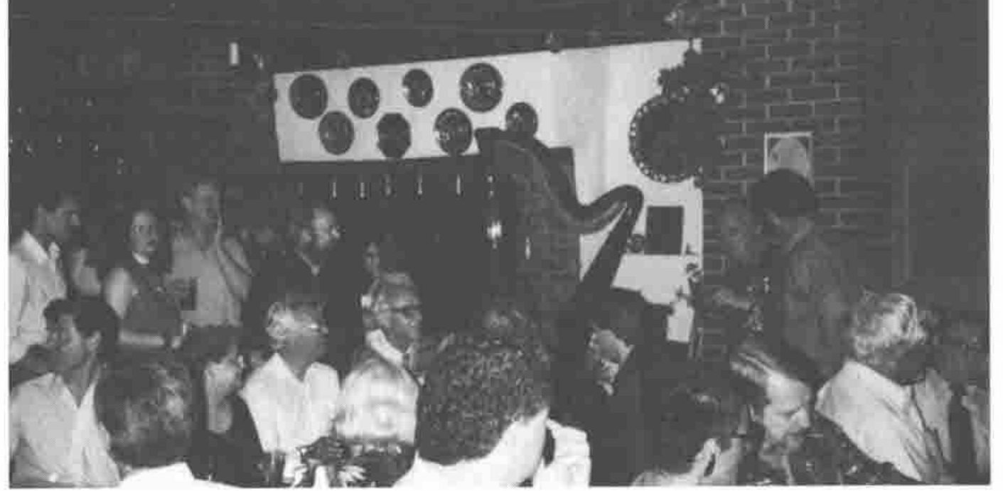 A crowded room with a harp in the background