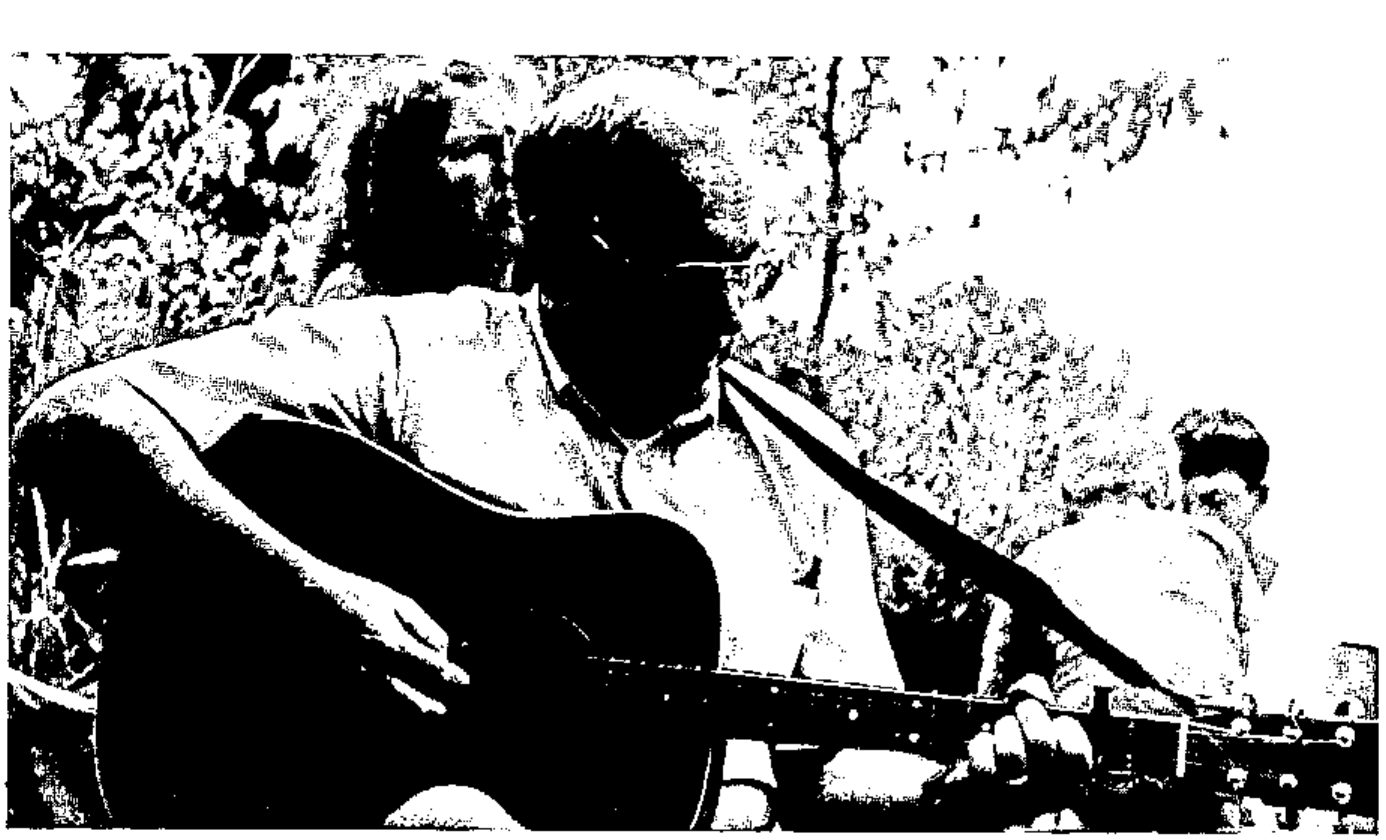 Photograph: Jim Brown playing the guitar at the conference picnic