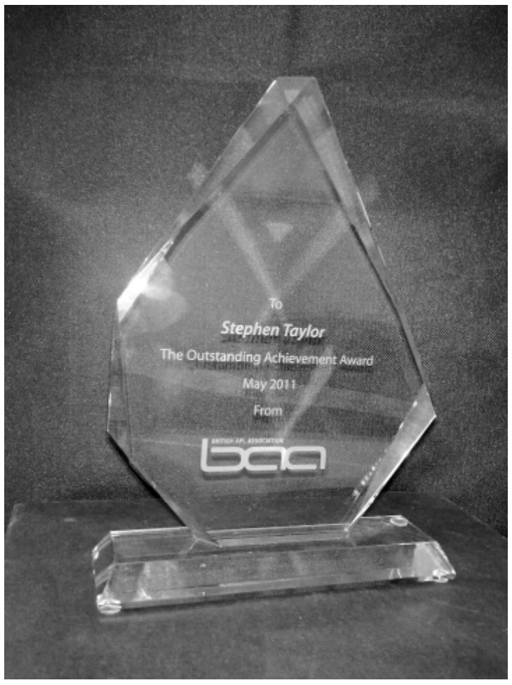 Photograph of the award: an engraved glass trophy bearing the BAA logo
