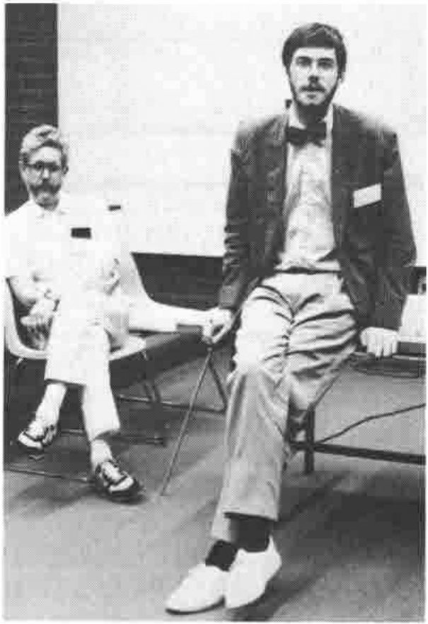 Photograph: Anthony Camacho, seated on a table, with Paul Chapman on a chair behind him