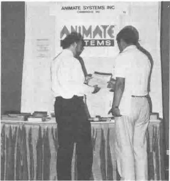 Photograph of two men examining a document at the Animate Systems Inc stand