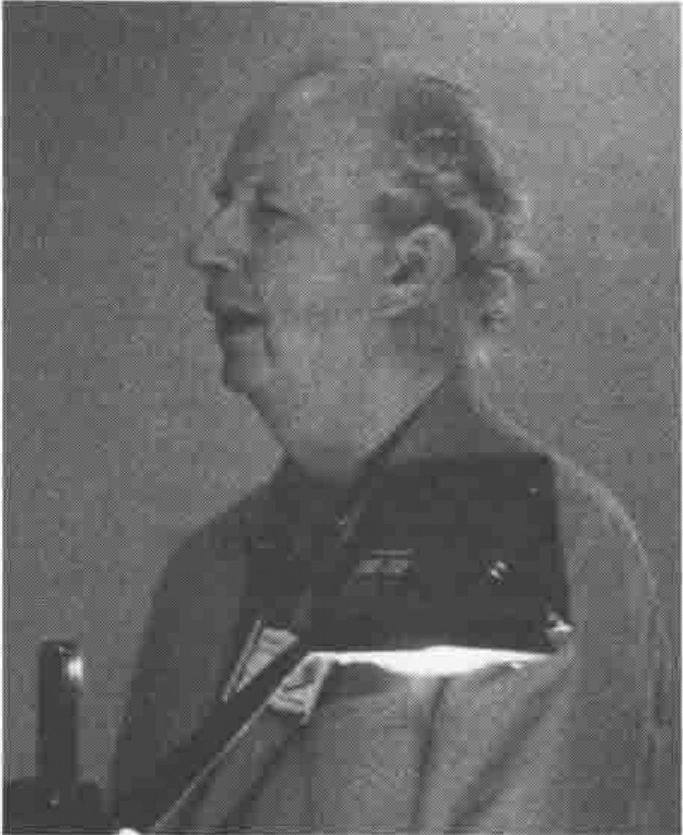 Photograph of Eugene McDonnell speaking, lit from below by a lectern lamp