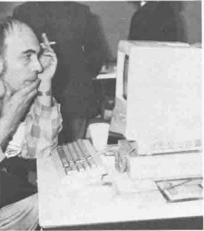 Photograph of Gérard Langlet, smoking, seated at a computer