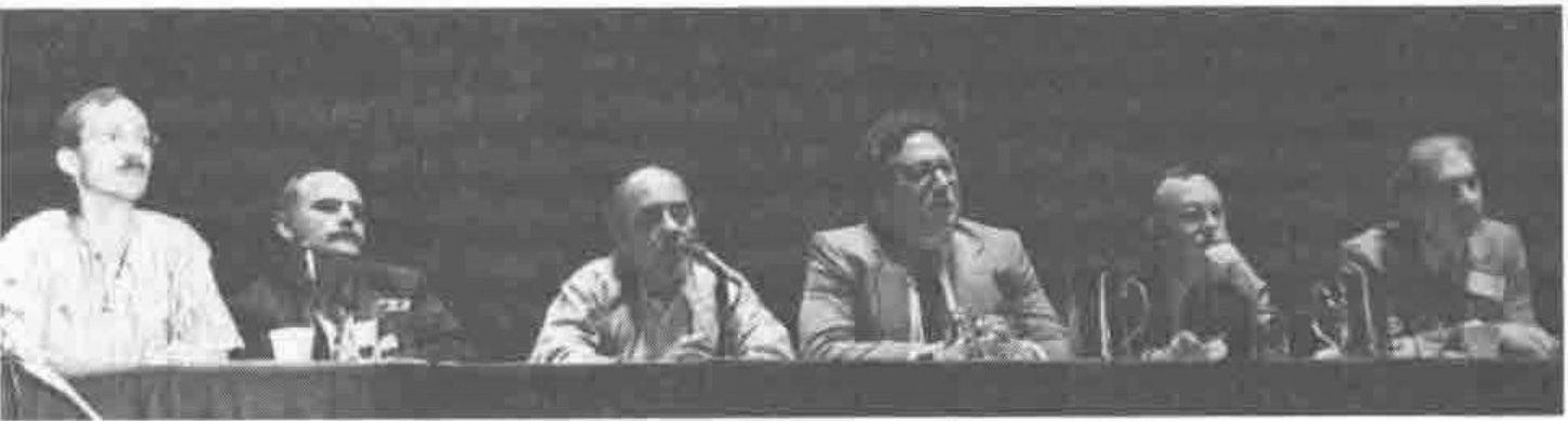 Photograph of five panellists seated at a table with microphones