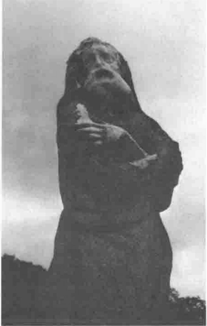 Photograph of a weathered standing statue of a robed figure