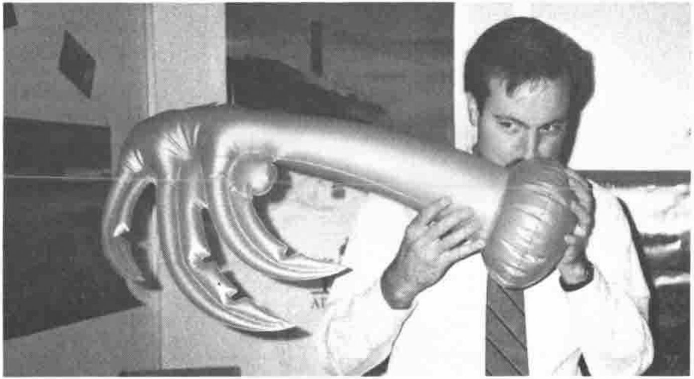 A man blowing up an inflatable palm tree