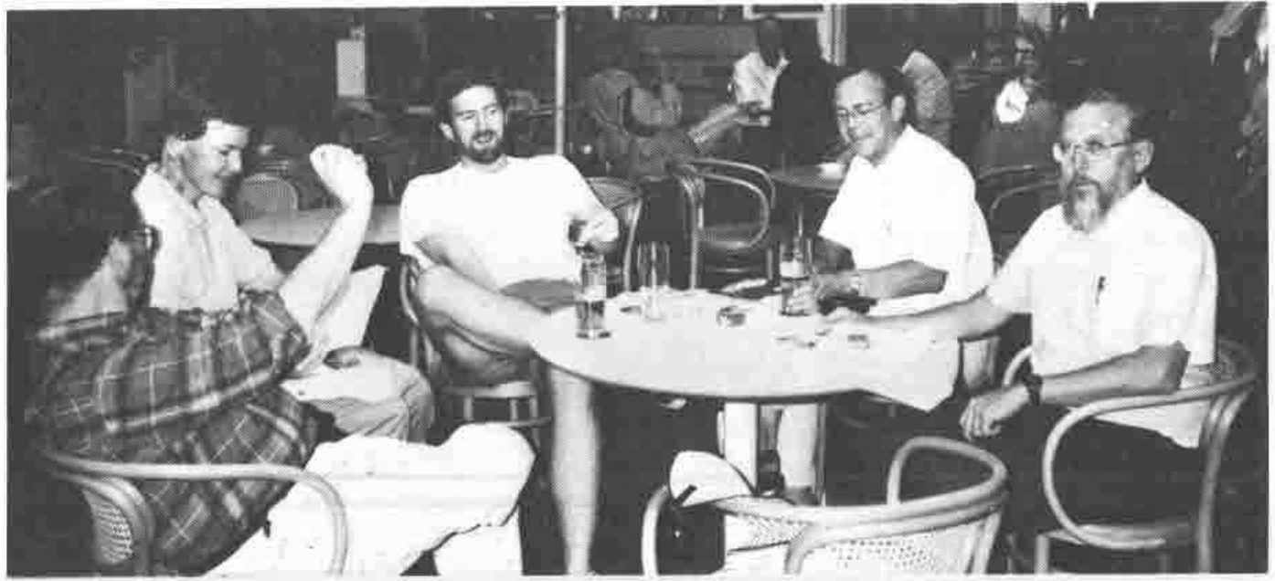 Five men relaxing round a café table