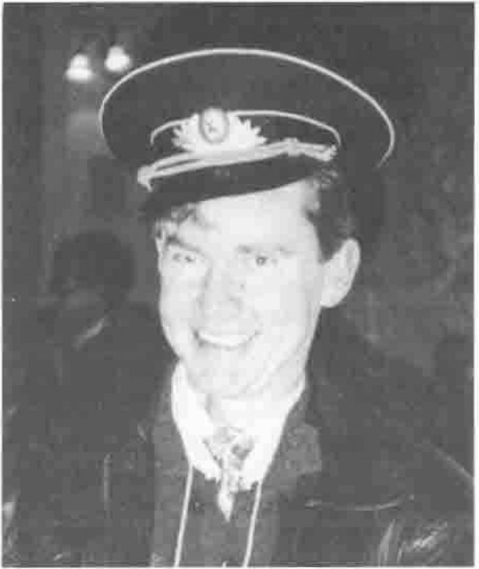 John Searle smiling, wearing a Russian military peaked cap